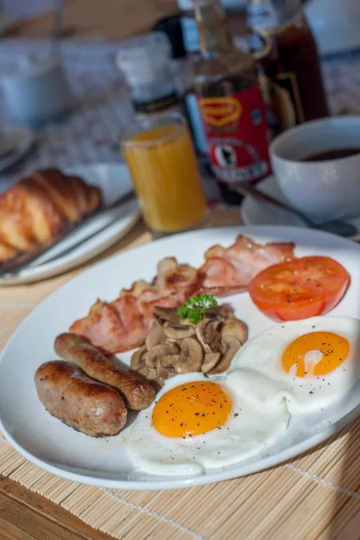 Cooked breakfast plate with eggs, bacon, sausage and a croissant