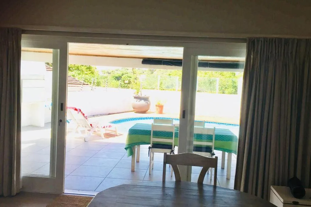Dining room sliding doors open directly onto the pool and covered outdoor dining area