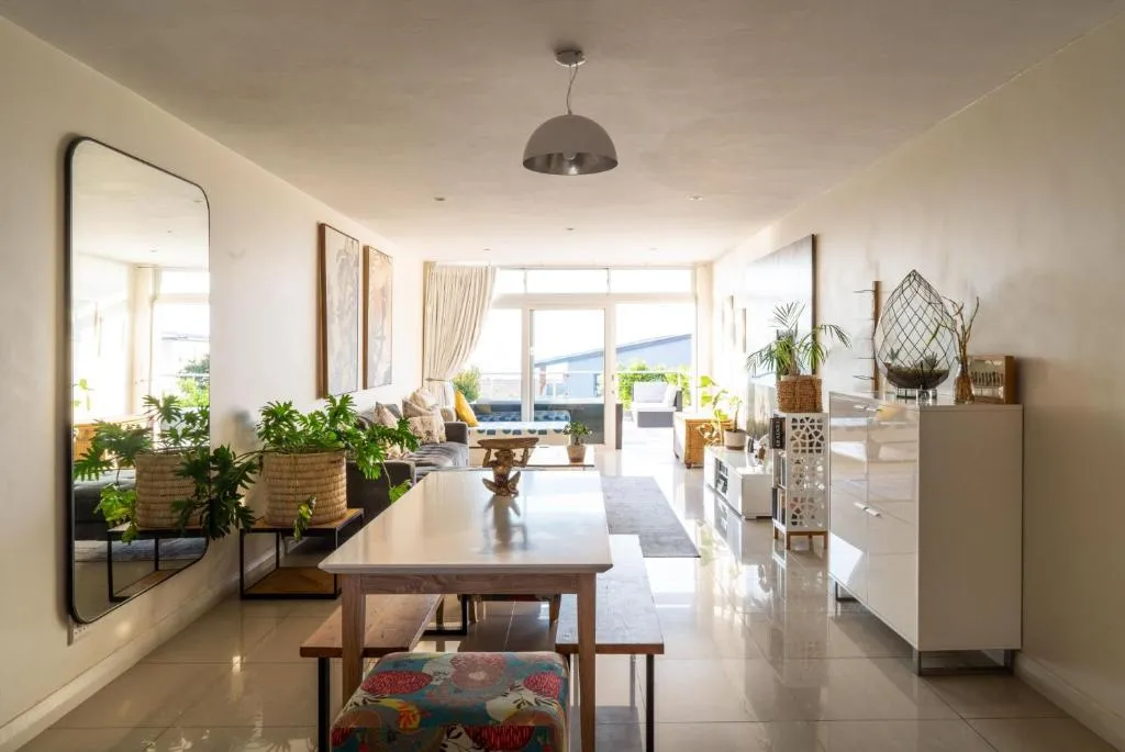 Open dining area with a wooden table, bench seating and a large wall mirror