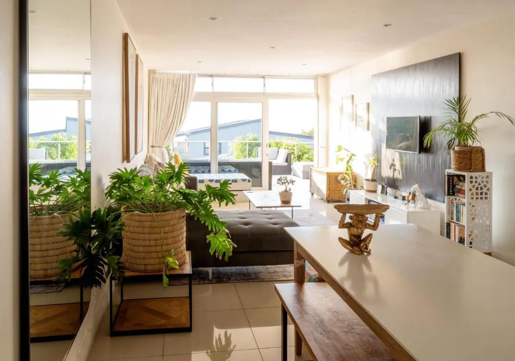 Living room with a grey sectional, wall-mounted TV and doors onto the balcony