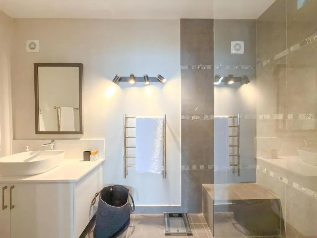 Bathroom with walk-in glass shower, double vanity and heated towel rail