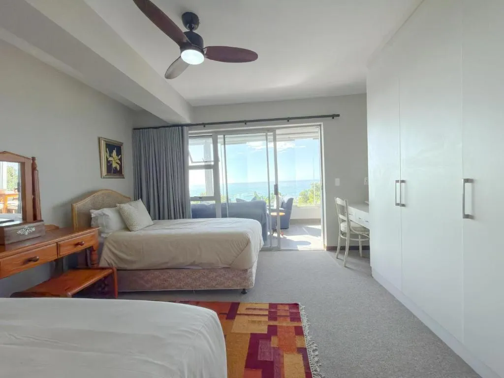 Twin bedroom with sliding doors opening to a balcony overlooking the sea