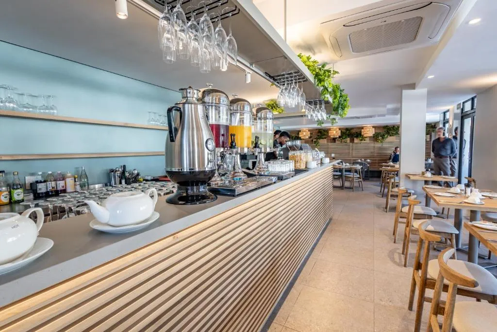 Breakfast bar with juice dispensers, hanging glassware and a hot drinks station in the hotel restaurant
