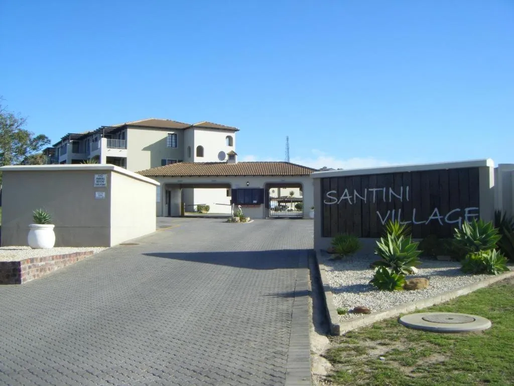 Santini Village estate entrance gate and boomed driveway beside the carved signage wall