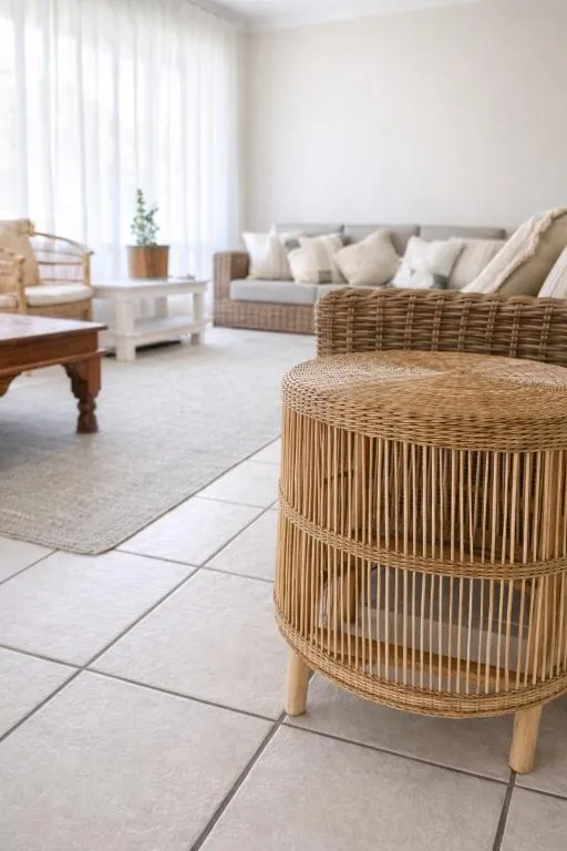 Close-up of a woven rattan side table with the lounge seating behind