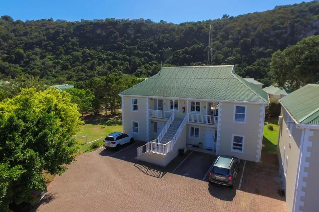 Aerial view of the house entrance with a staircase and cars parked below