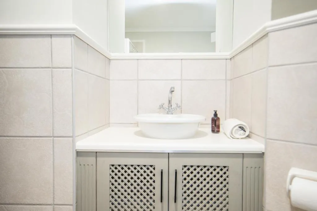 Bathroom with a tiled vanity, oval countertop basin, and chrome mixer tap