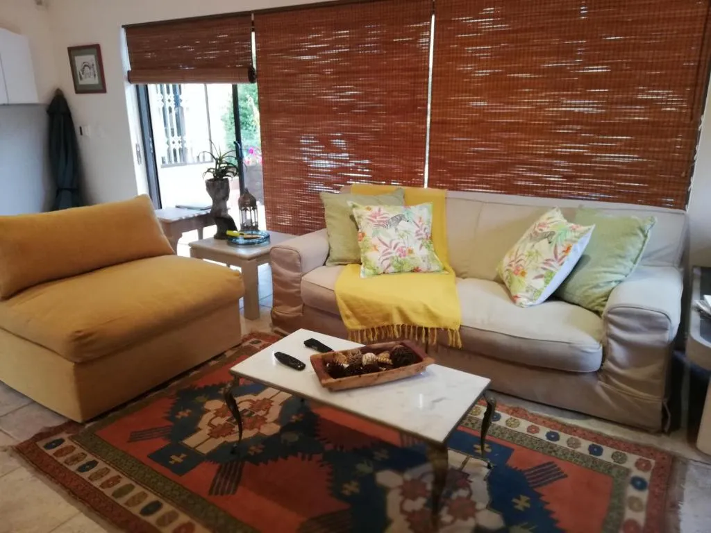 Living room with a cream sofa, mustard armchair and patterned kilim-style rug