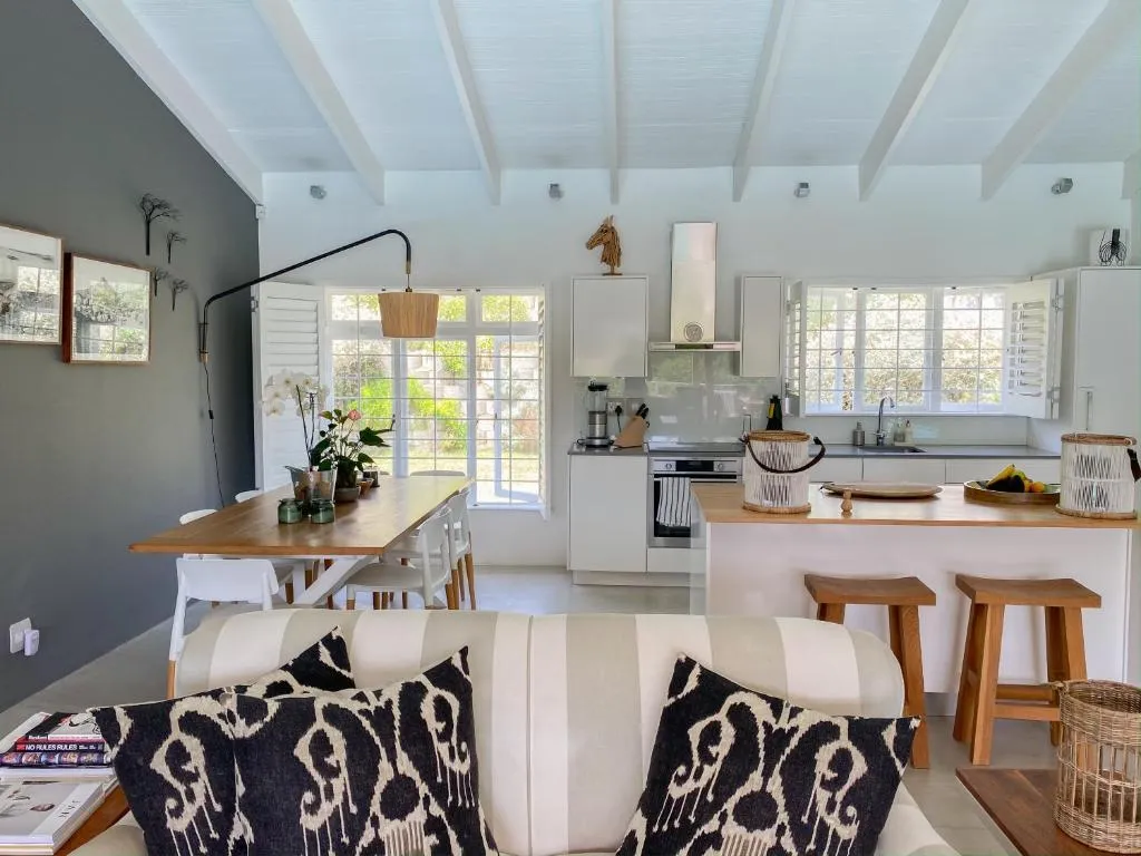 Open-plan kitchen and dining area with a wooden table for six and a striped sofa in the foreground