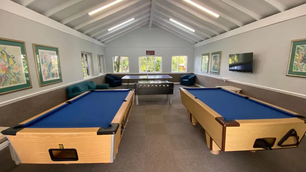 Shared games room with two full-size pool tables and a foosball table