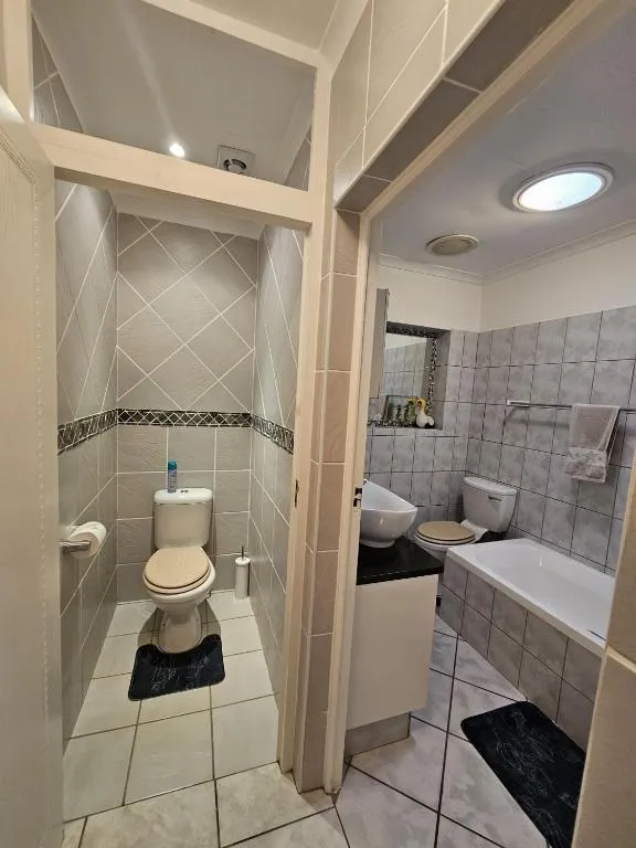 Bathroom with a separate toilet nook, freestanding bath and vessel sink