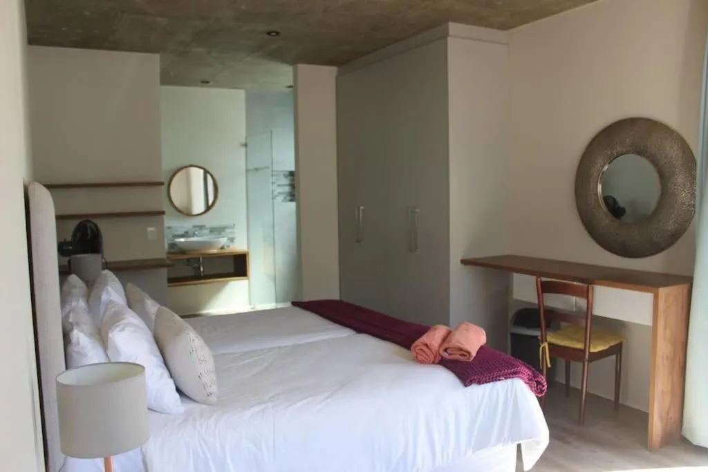 Main bedroom with an open en-suite bathroom, round mirror and dressing table
