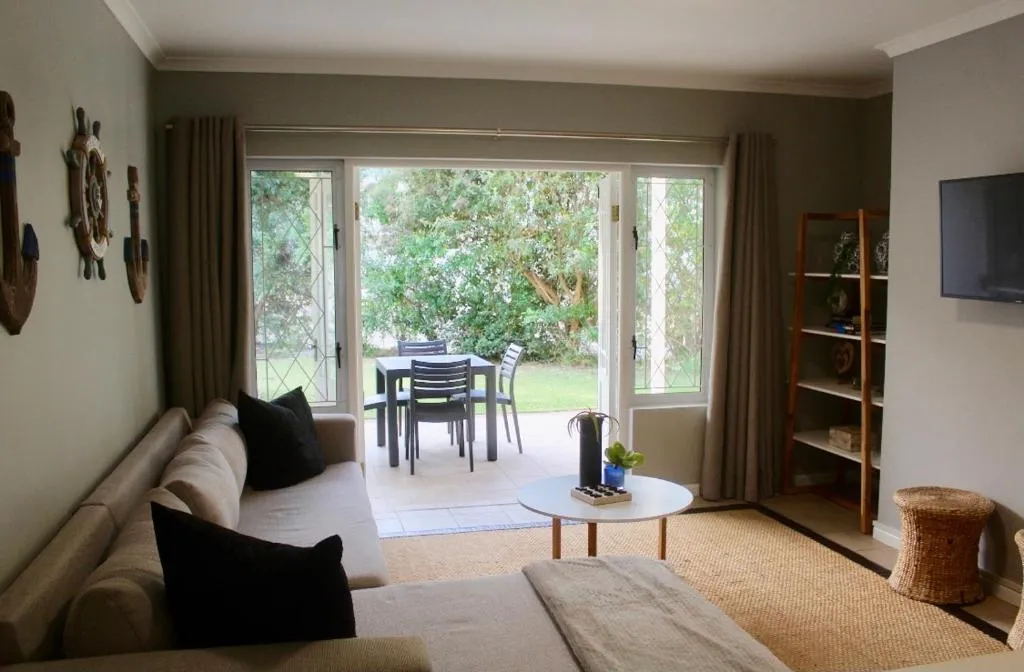 Living room with beige sofas and glass doors opening onto the patio dining area