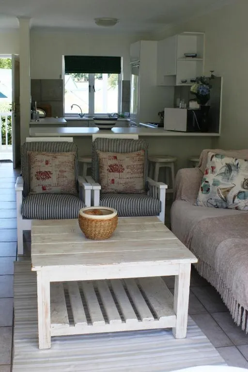 Open-plan living room with breakfast-bar kitchen, armchairs and a wooden coffee table