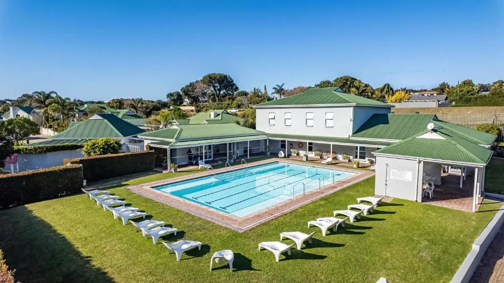 Aerial view of the estate's communal swimming pool, clubhouse and sun loungers on the lawn