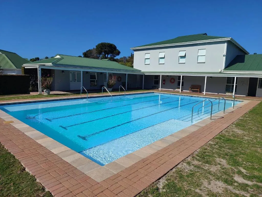Communal swimming pool with lane markers beside the clubhouse building