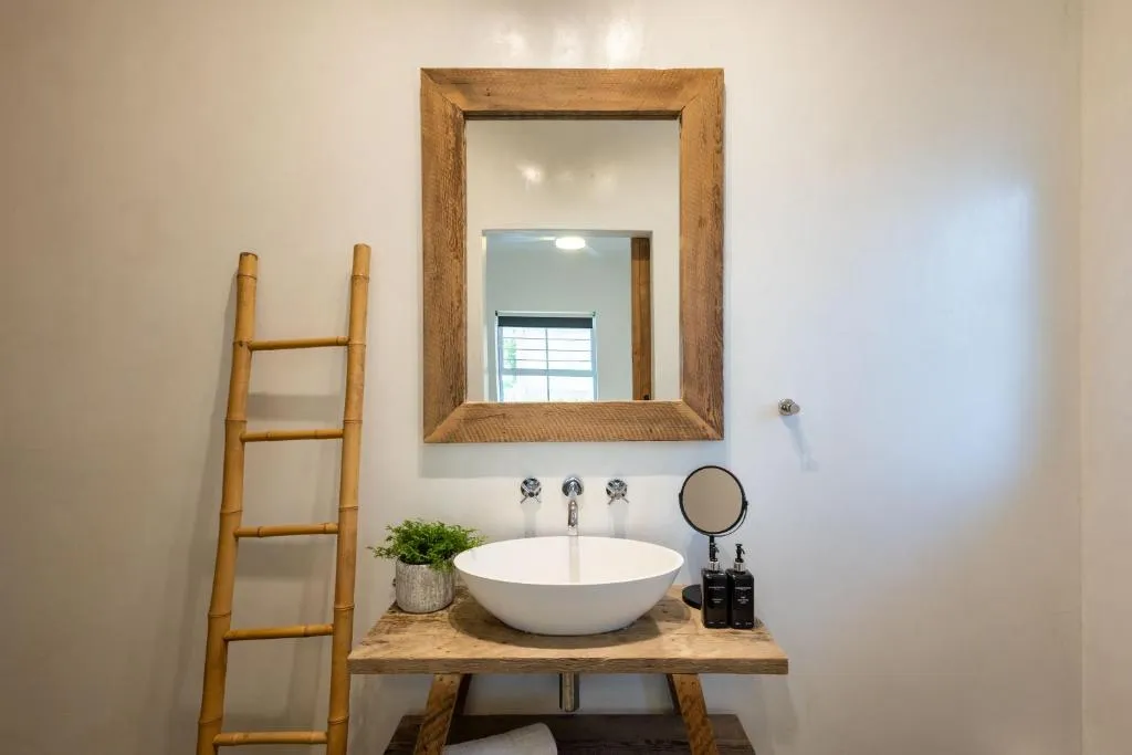 Bathroom vanity with round basin, wooden counter and bamboo ladder towel rail