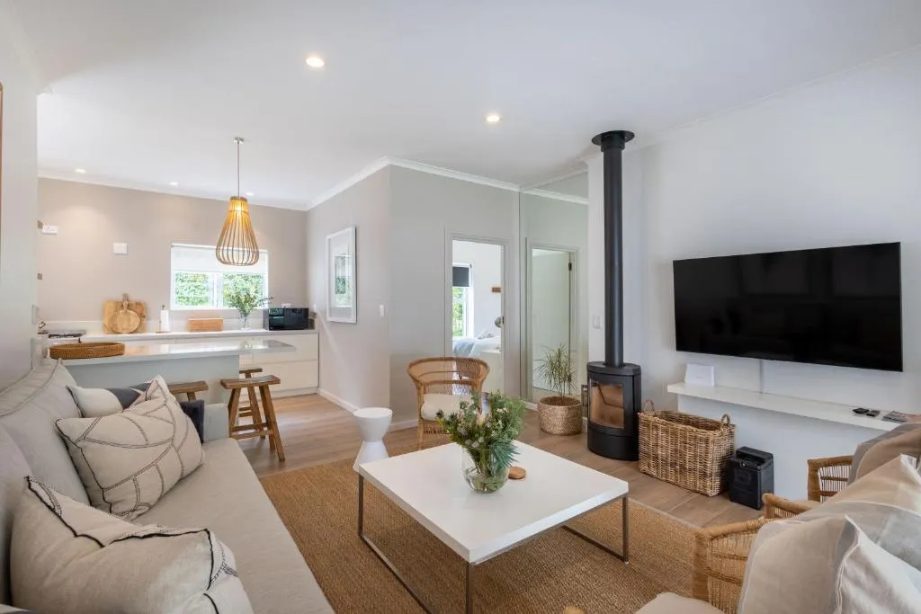 Open-plan living room with wood-burning stove, TV and a view through to the kitchen