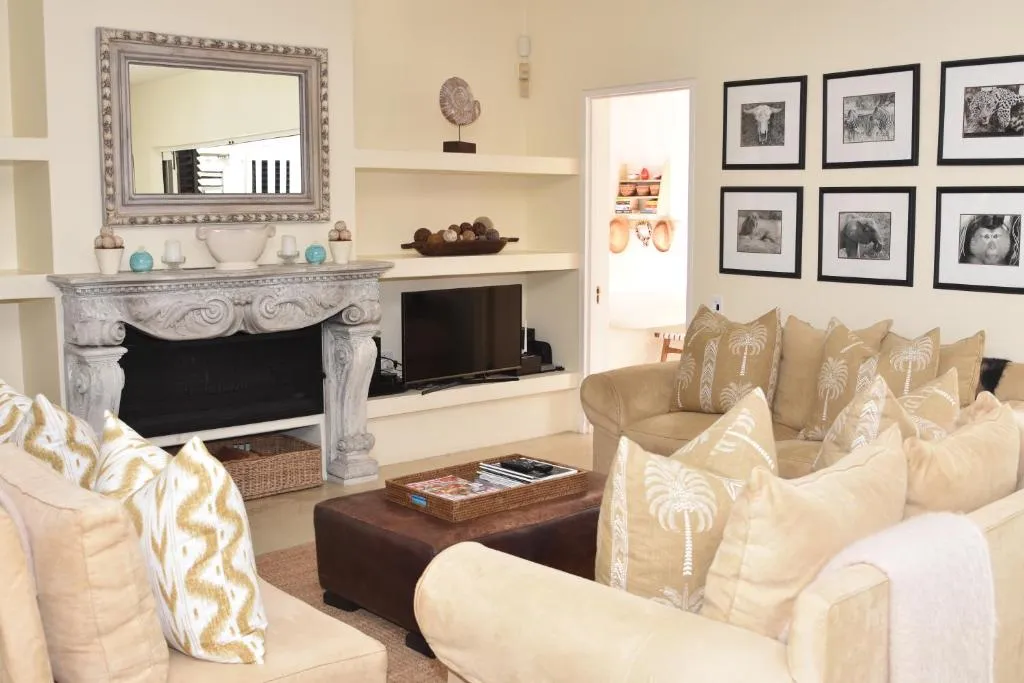 Living room with a carved stone fireplace, wildlife photography gallery wall and cream sofas