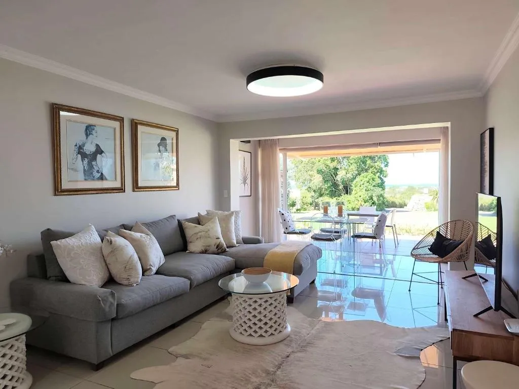 Living room with a grey L-shaped sectional couch and framed artwork opening onto the patio