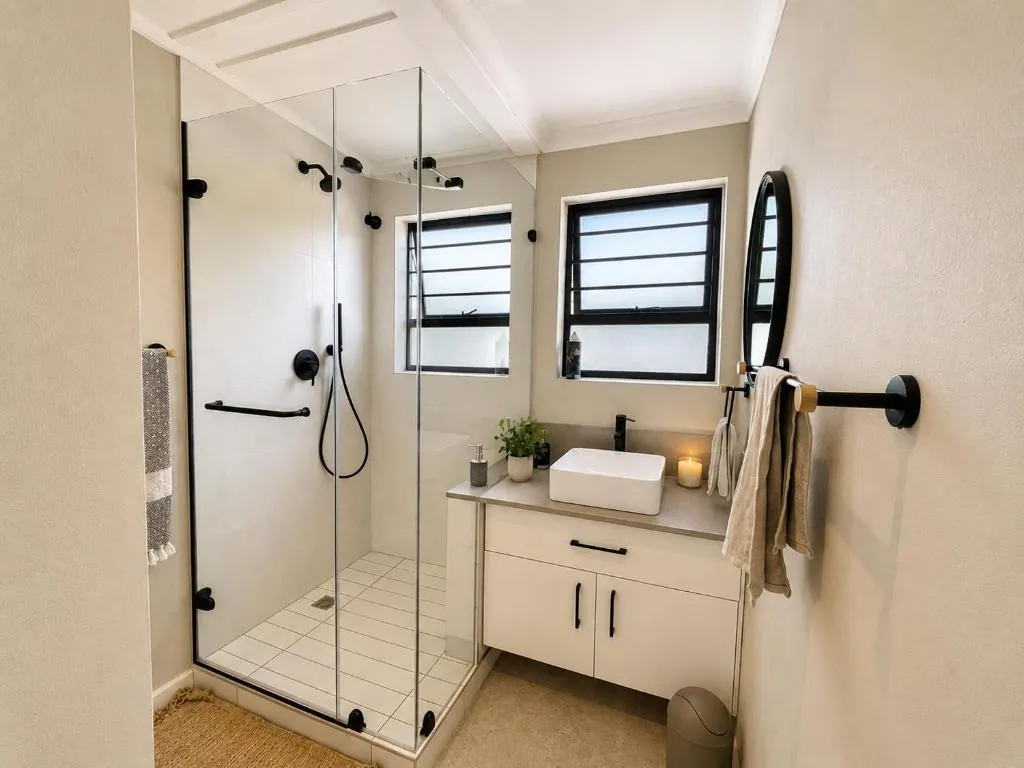 Bathroom with a frameless glass shower, black fixtures, and a white vessel sink