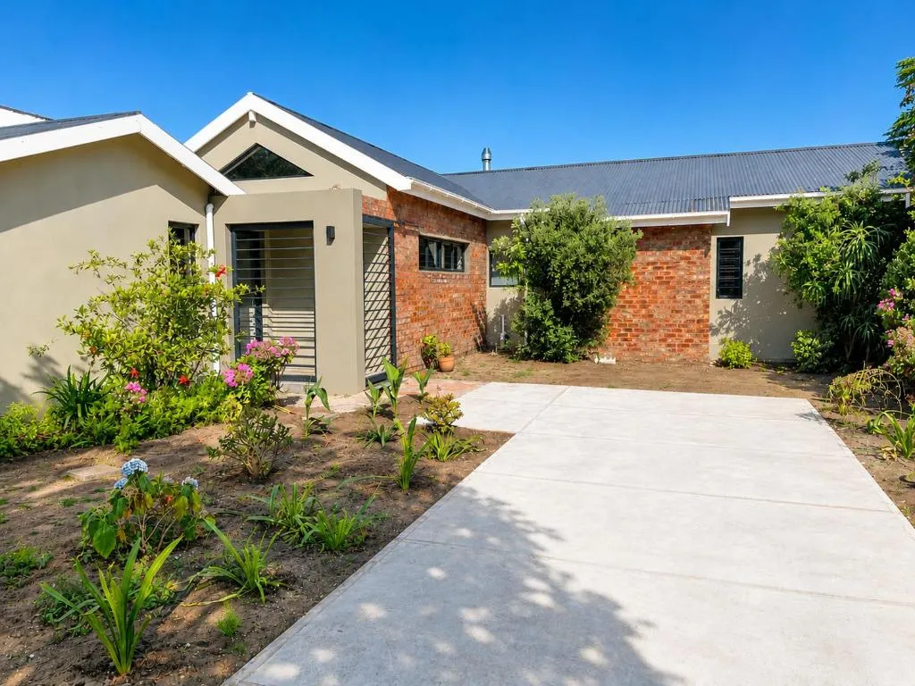 Brick and stucco holiday home exterior with a planted garden and driveway