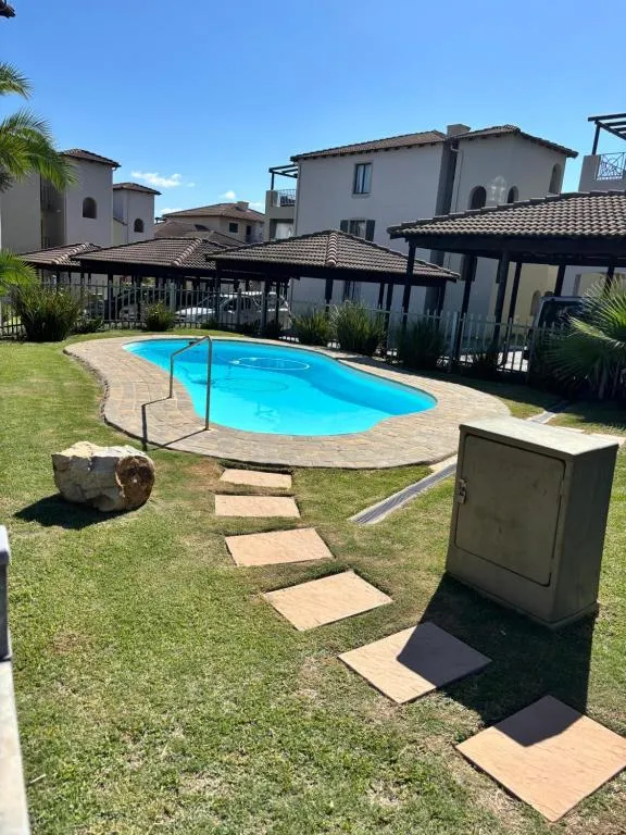 Shared complex pool with paved surround, set among the townhouse buildings