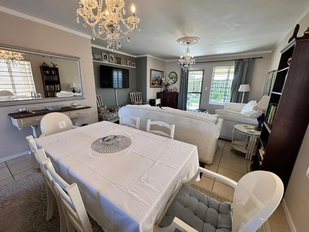 Dining area for six beneath a crystal chandelier, with a mirrored console table