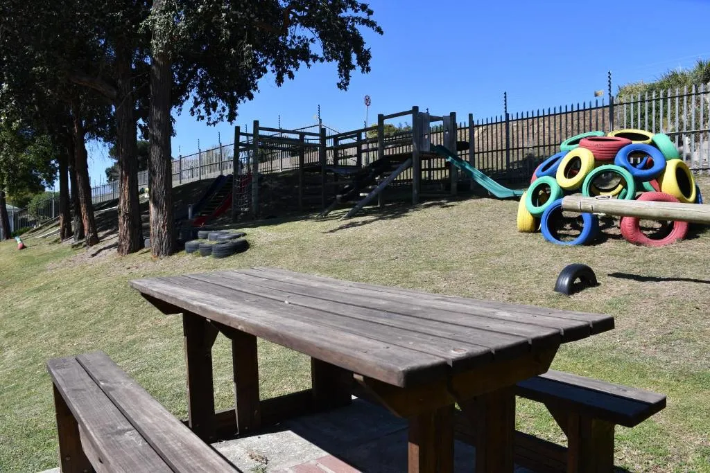 Children's playground with tyre climbing frame on the River Club estate lawn
