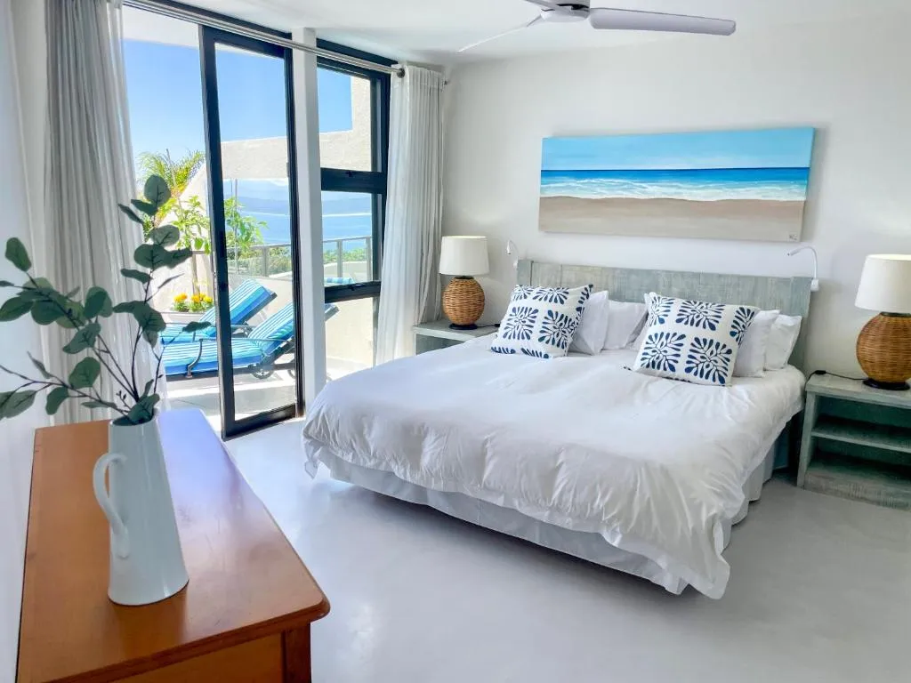 Bedroom with a king bed and sliding glass doors opening onto a balcony sea view