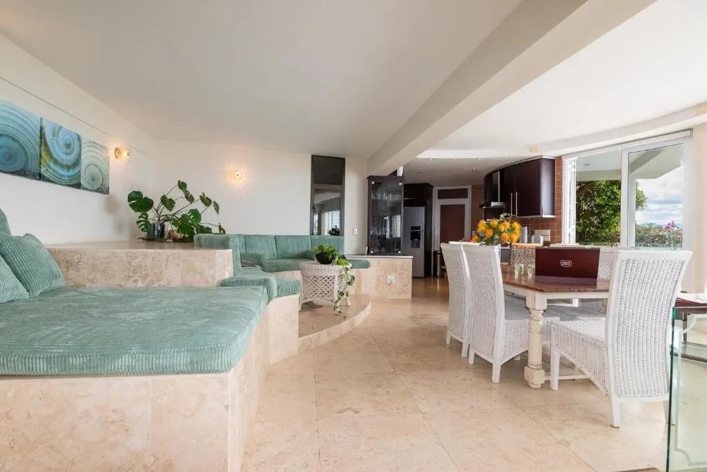 Living and dining area with built-in teal seating and an open-plan kitchen