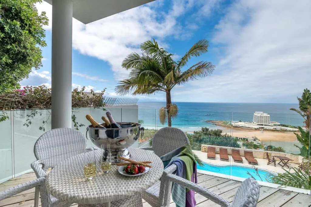 Terrace table with champagne and strawberries overlooking the pool and ocean
