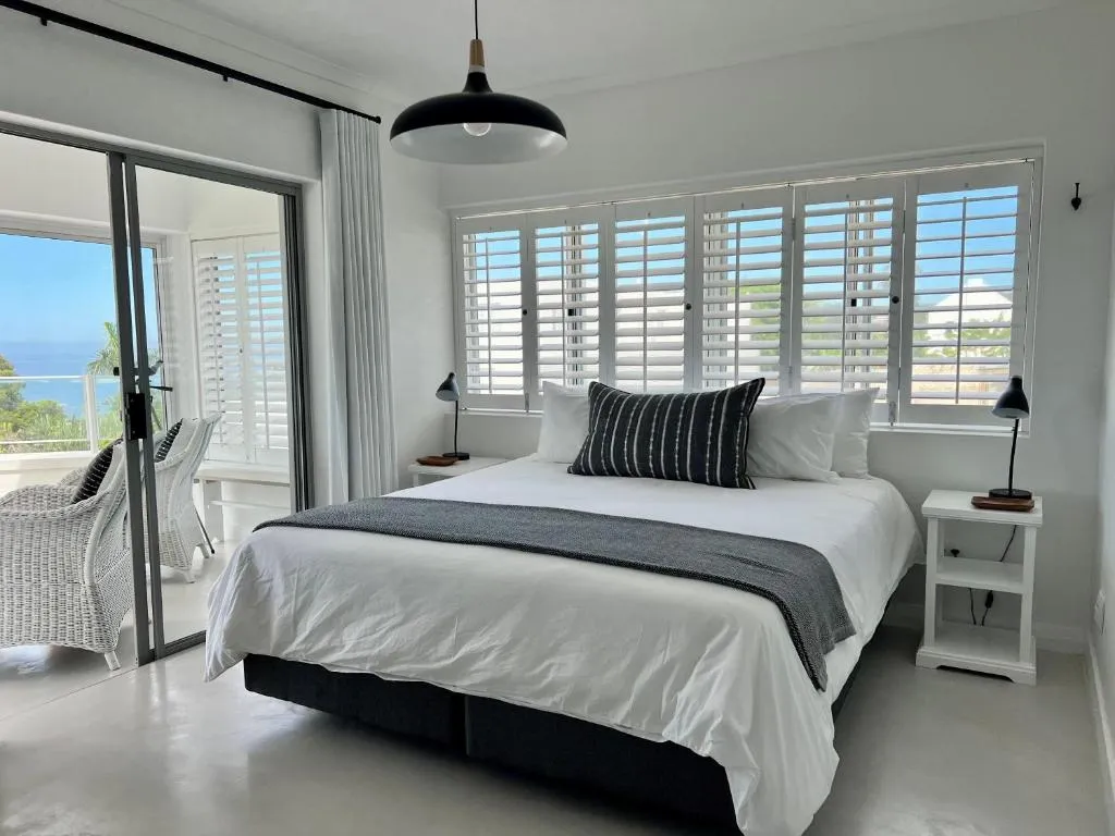 Main bedroom with sliding doors opening onto a private balcony overlooking the sea