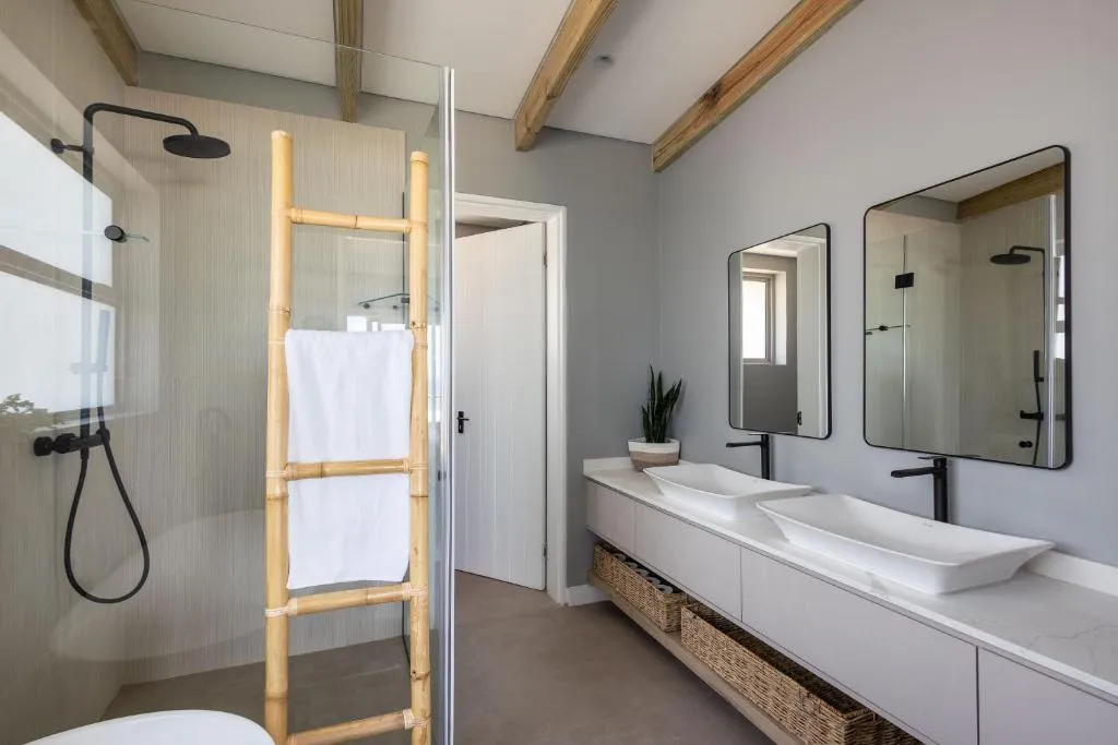 Bathroom with a double vanity, walk-in shower and a bamboo towel ladder