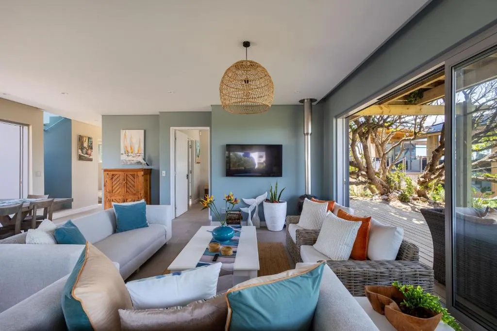 Living room with a wood-burning stove and sliding doors onto a tree-lined deck