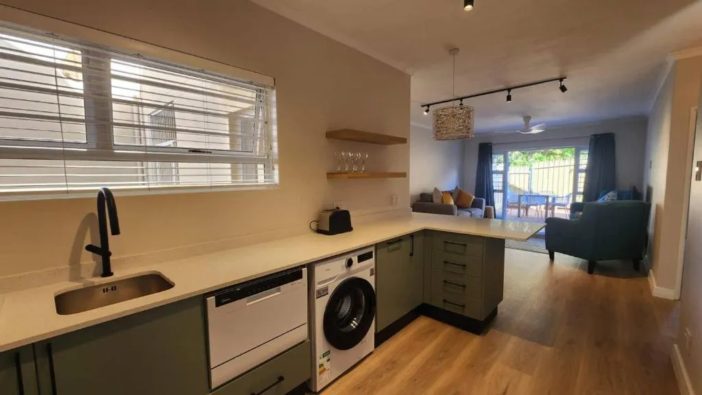 Galley kitchen with washing machine, dishwasher, and pass-through to the lounge