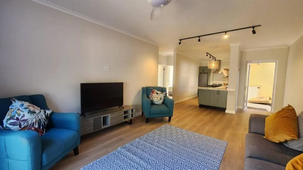 Second view of the open-plan lounge, kitchen, and blue-tiled patterned rug