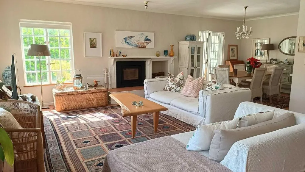 Living room with a fireplace, upholstered sofas and a dining area beyond
