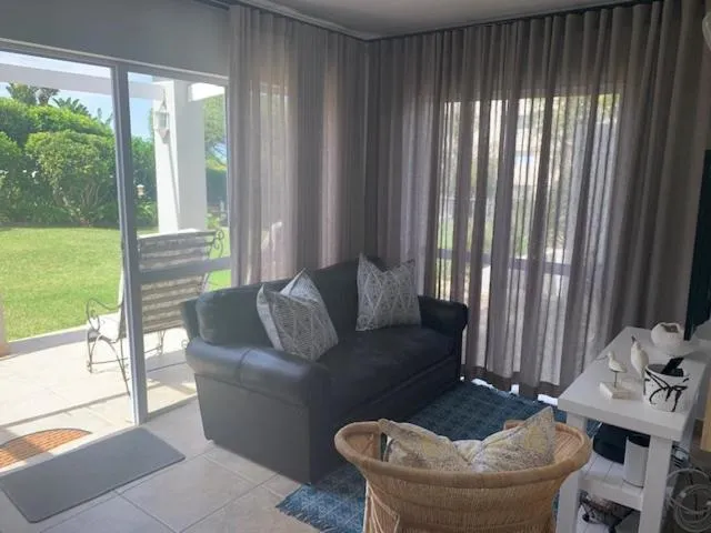 Lounge opening onto a paved patio and lawn through sliding glass doors