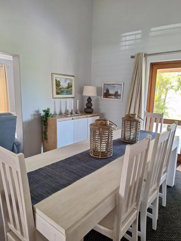 Dining table for six with woven lanterns, a table runner and doors onto the garden