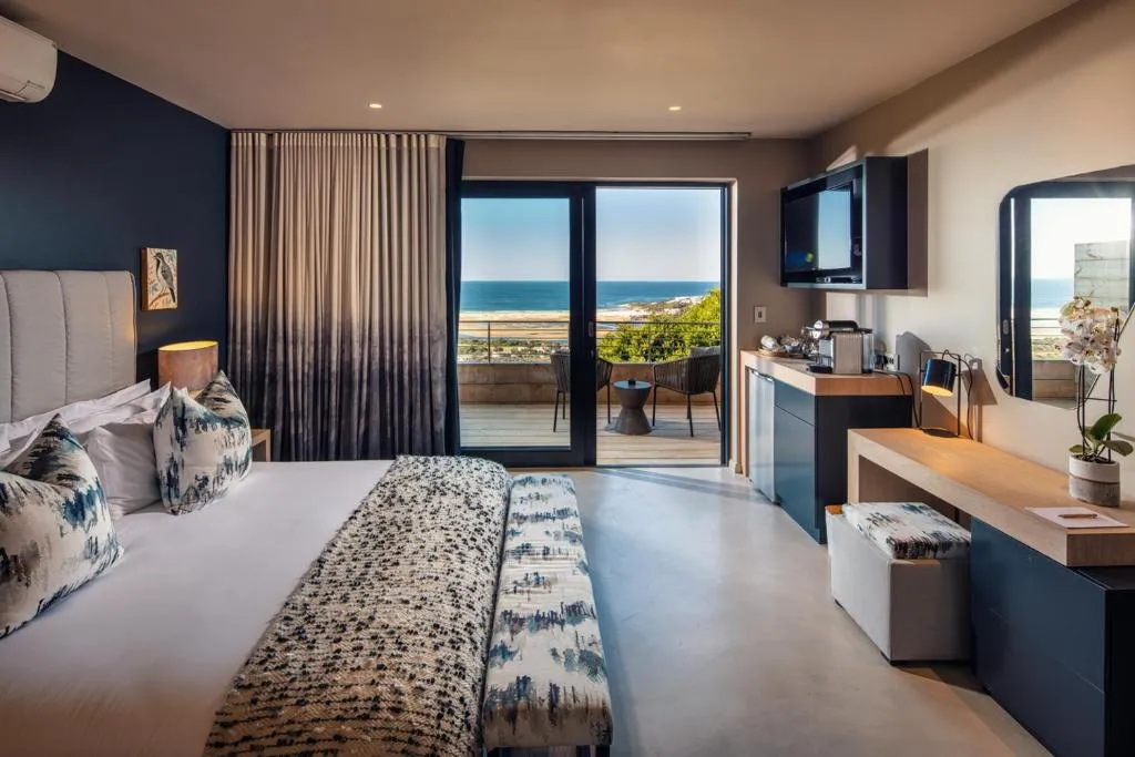 Bedroom with a private balcony and sliding doors framing an uninterrupted sea view