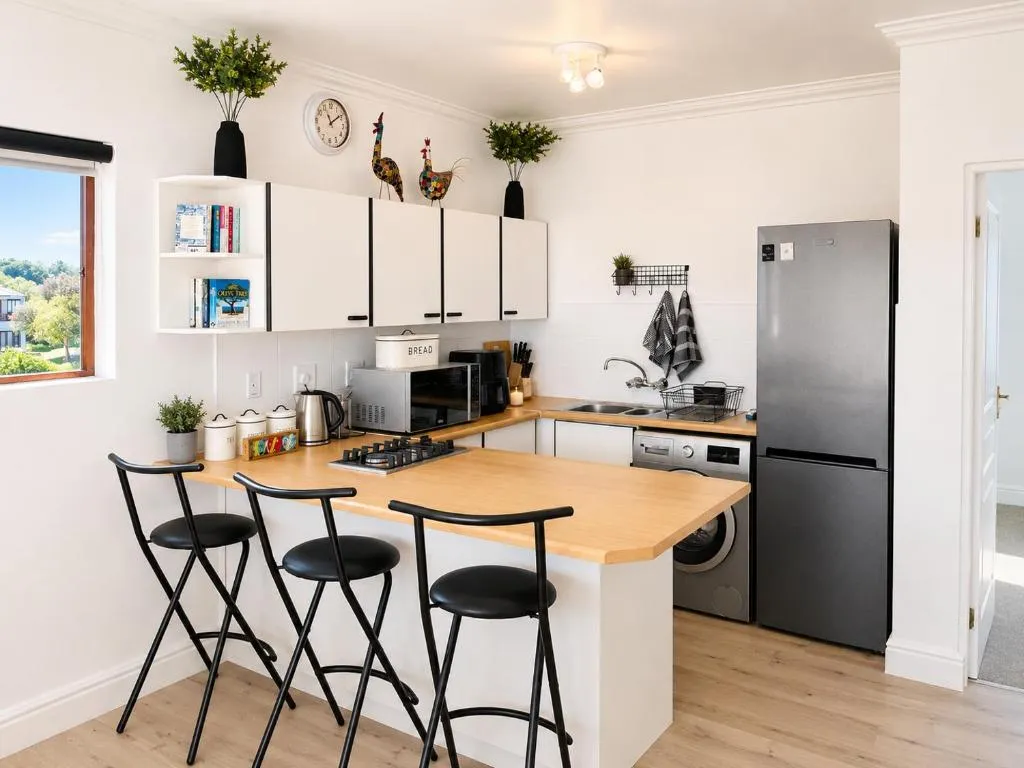 Kitchen with built-in washing machine, gas hob, fridge and breakfast bar seating