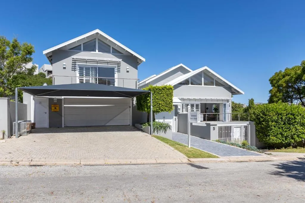 Street view of the two-storey house with a double carport and paved driveway