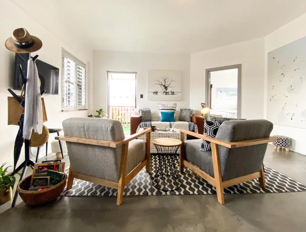Living room with reading chairs, an elephant print, and a door onto the balcony