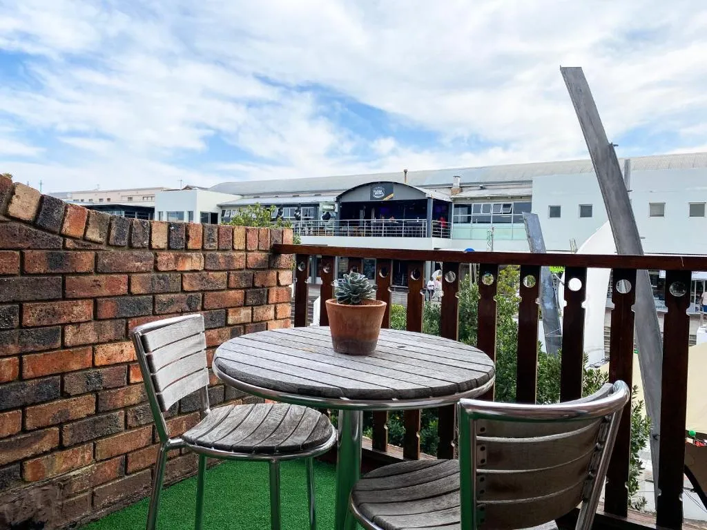 Small rooftop balcony with a bistro table and chairs overlooking the town rooftops