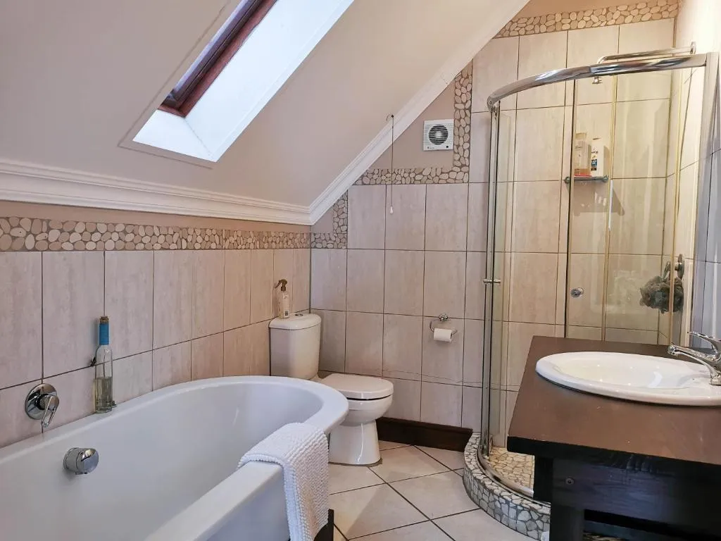 Bathroom with a freestanding tub, skylight and a separate corner shower