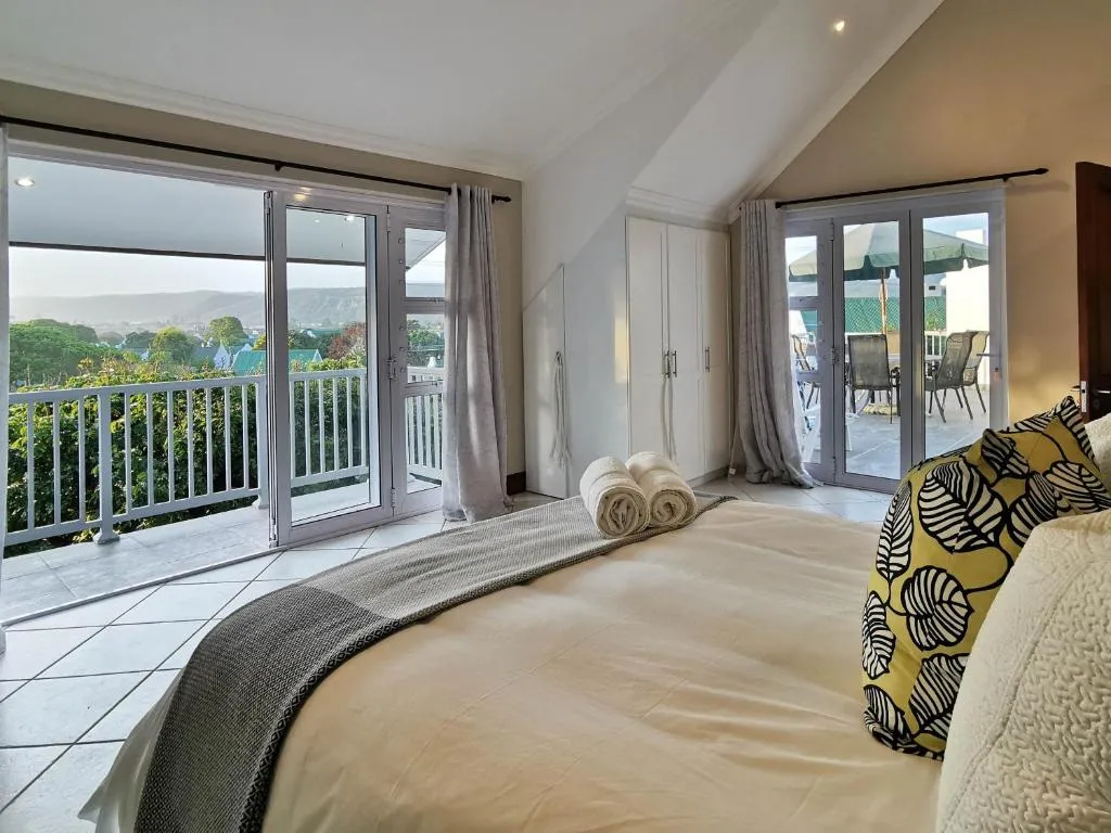 Bedroom with French doors opening onto a balcony over the Keurbooms lagoon and hills
