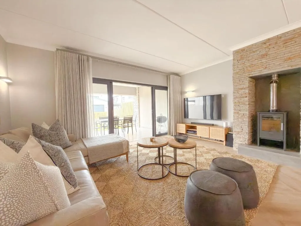 Living room with a slate-clad wood-burning fireplace and sliding doors onto the patio