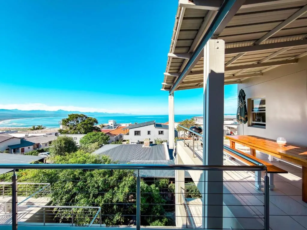 Covered terrace balcony with sea view over rooftops toward distant mountains