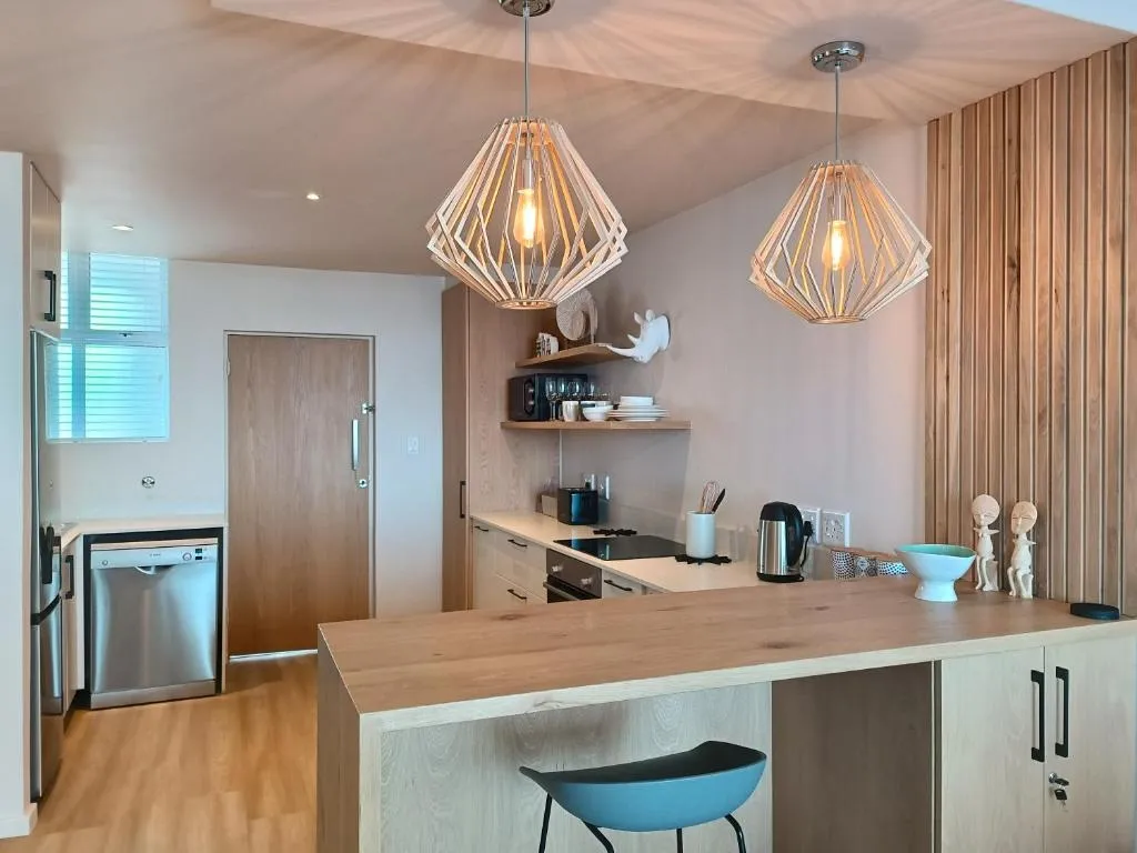 Kitchen with timber pendant lights, a breakfast bar and built-in dishwasher